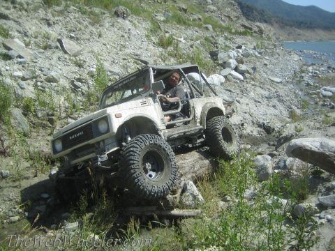1987 Suzuki Samurai - Suzuki Samurai tackling rough terrain on a sunny day.