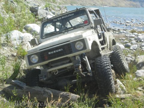 1987 Suzuki Samurai - This modified 1987 Suzuki Samurai navigates a challenging rocky path near a body of water.
