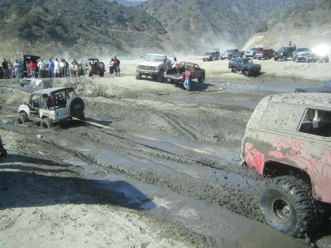 1987 Suzuki Samurai - Multiple off-road vehicles are stuck in thick mud during an outing.