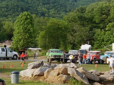 1990 Ford Bronco - Several off-road vehicles, including a green 1990 Ford Bronco, are gathered in a rocky, outdoor area.