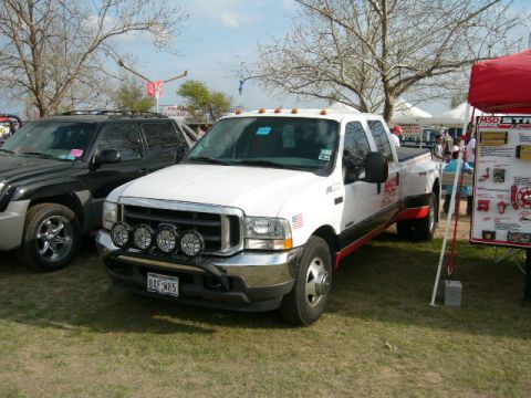 1978 Ford Bronco - White Ford F-350 dually pickup truck with aftermarket lights and red trim parked next to a black SUV.