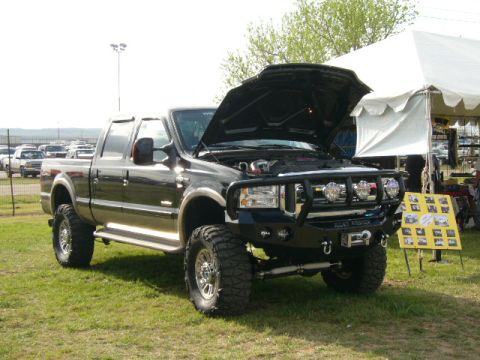1978 Ford Bronco - This black pickup truck is on display with its hood open, showing off its engine bay.