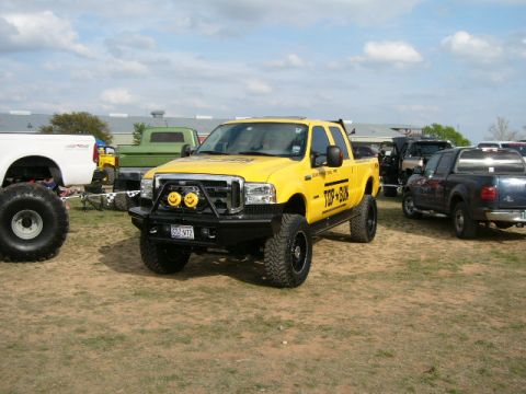 1978 Ford Bronco - Modified yellow Ford F-Series truck with "TOP GUN" graphics and custom bumper.