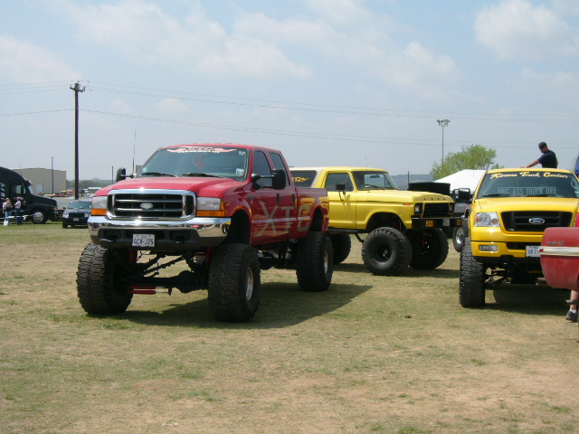 Red Ford F-250 truck with lifted suspension and large tires, front view