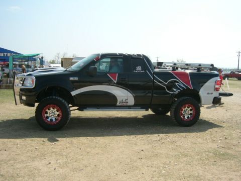 1978 Ford Bronco - This modified black Ford F-150 pickup truck features custom graphics and lifted suspension.