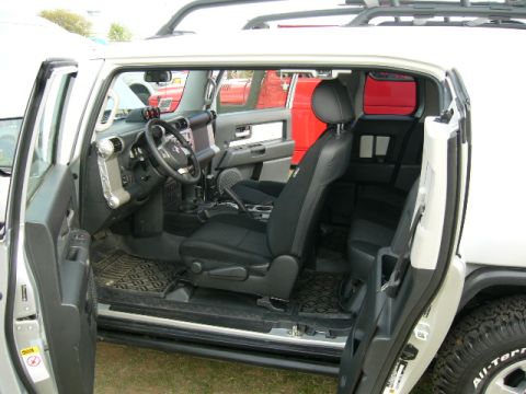 1978 Ford Bronco - The interior of a white SUV is shown with its doors open, revealing the seats and dashboard.