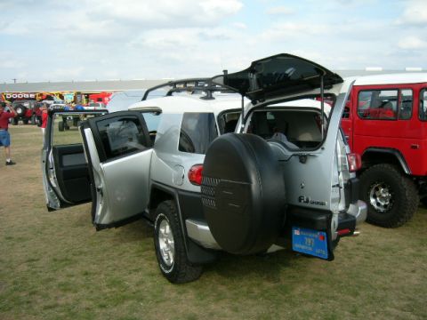 1978 Ford Bronco - A silver Toyota FJ Cruiser is parked with its doors and rear hatch open, alongside other vehicles.