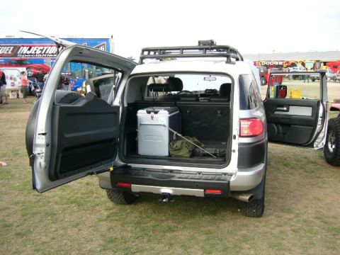 1978 Ford Bronco - Rear view of a Toyota FJ Cruiser loaded with a cooler and gear, with another vehicle nearby.