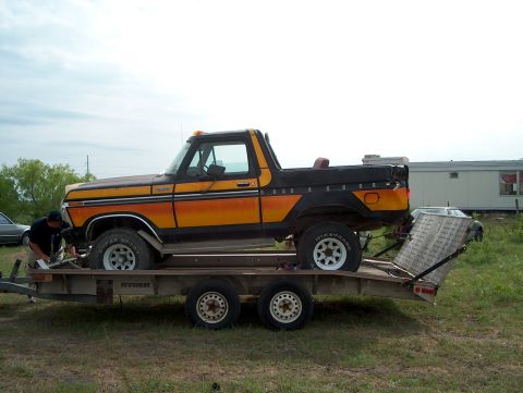 1979 Ford Bronco - A man secures a vintage Ford Bronco onto a trailer, preparing it for transport.