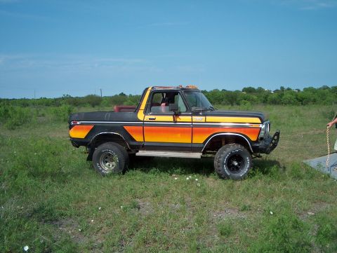 1979 Ford Bronco - This lifted Ford Bronco features a distinctive black, yellow, and orange stripe paint job.