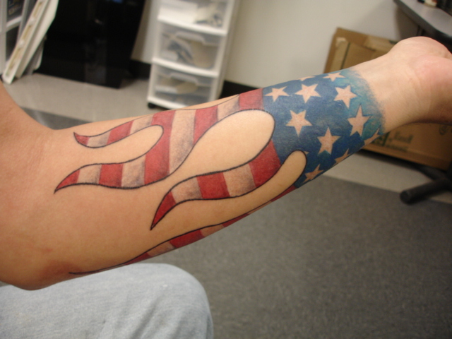 Arm tattoo with American flag and flames