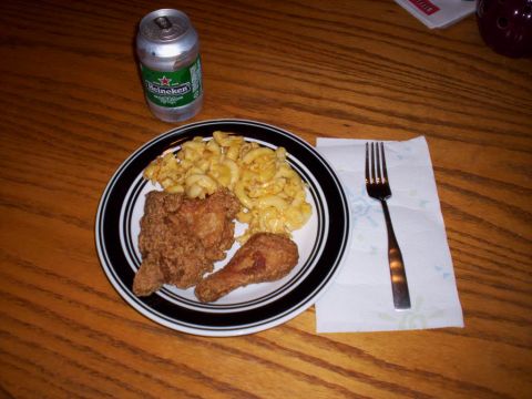 1989 Ford Bronco - A meal of fried chicken and mac and cheese is served with a Heineken and a fork on a wooden table.
