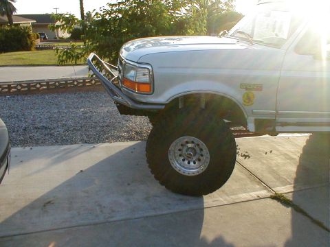 1996 Ford Bronco - The front quarter panel of a silver Ford Bronco shows a "Bronco" badge and a custom bumper.