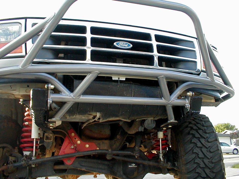 Gray custom front bumper and grille on a 1992 Ford Bronco with red suspension components