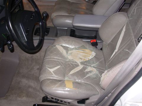 1995 Ford Taurus - The interior of a car shows significant wear and tear on the seats.