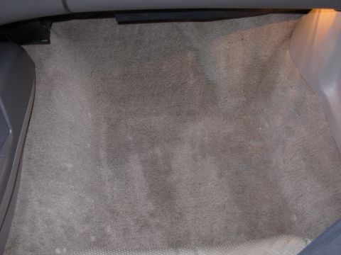 1995 Ford Taurus - The interior floor carpet of a vehicle is visible, showing a gray, textured surface.