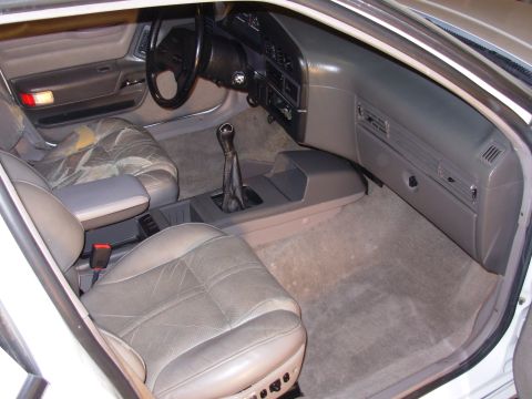 1995 Ford Taurus - The interior of this car features worn leather seats and a manual shifter, indicating a focus on driving experience.
