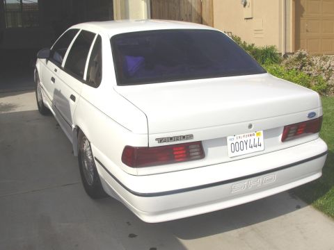 1995 Ford Taurus - 1995 Ford Taurus SHO sedan seen from the rear, parked in a driveway.