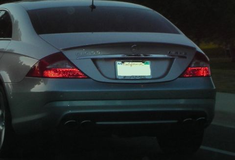 1998 Ford Crown Victoria - Rear view of a silver Mercedes-Benz CLS 55 AMG sedan with distinctive taillights and quad exhaust pipes.