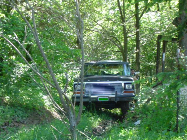 1978 Ford Bronco front view, parked off-road in a wooded area