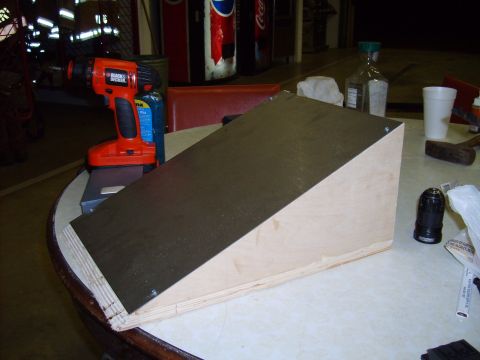 2004 Ford Crown Victoria - A wooden ramp with a black surface is shown, alongside a drill and other items on a table.