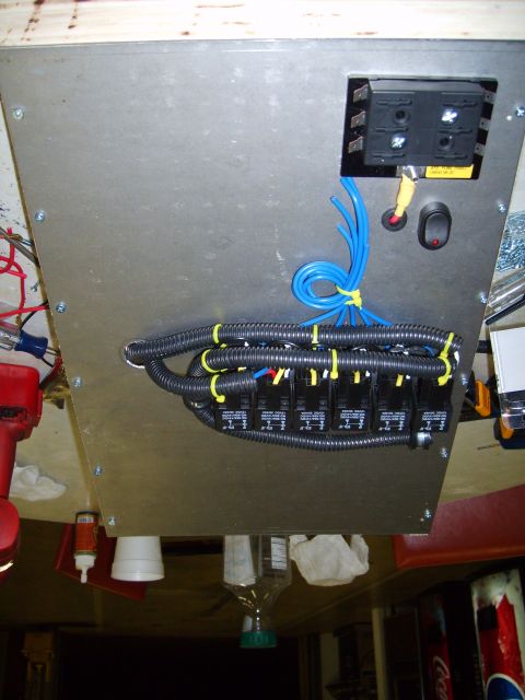 2004 Ford Crown Victoria - A custom wiring harness a fuse box and multiple relays is installed on a metal panel, likely for aftermarket electrical components.