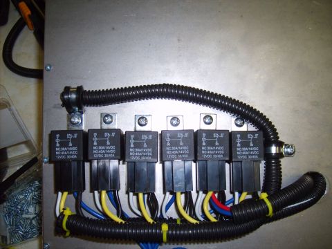 2004 Ford Crown Victoria - Automotive relay wiring harness with multiple relays and protective conduit shown.