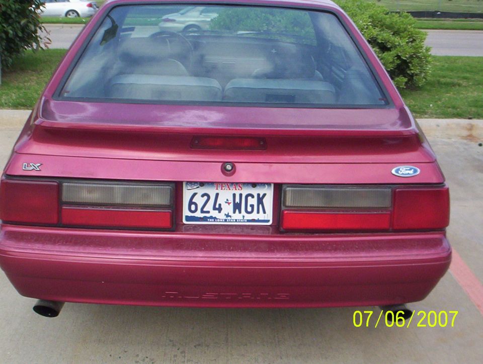Rear of a maroon Fox-body Ford Mustang LX hatchback with Texas plate