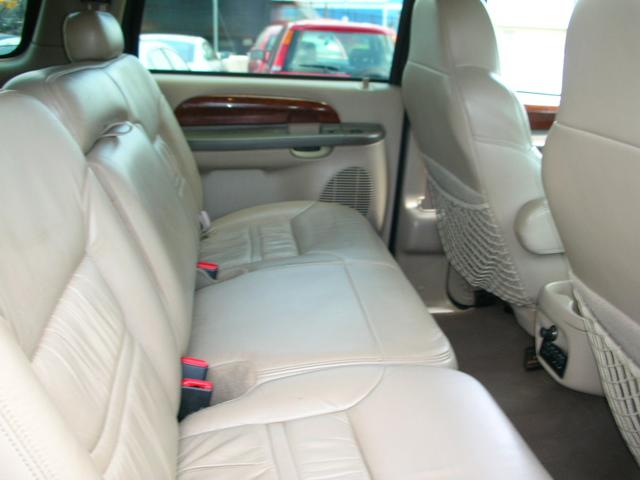 Tan leather rear bench seat inside an SUV with mesh seatback pocket