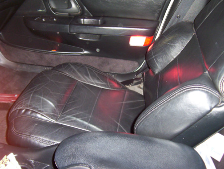 1993 Ford Taurus - Close-up of the driver's side interior, showing worn black leather seats and door trim.