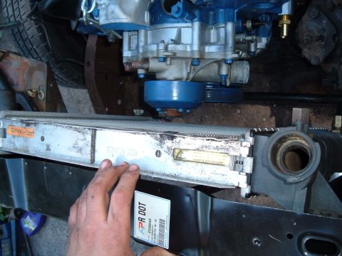 1990 Ford Ranger - Engine and radiator components are visible, with a hand holding a sticker labeled 'PR DOT'.