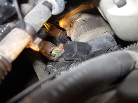 1995 Ford Taurus - A close-up view of a vehicle's engine wiring harness, showing exposed wires and connectors.