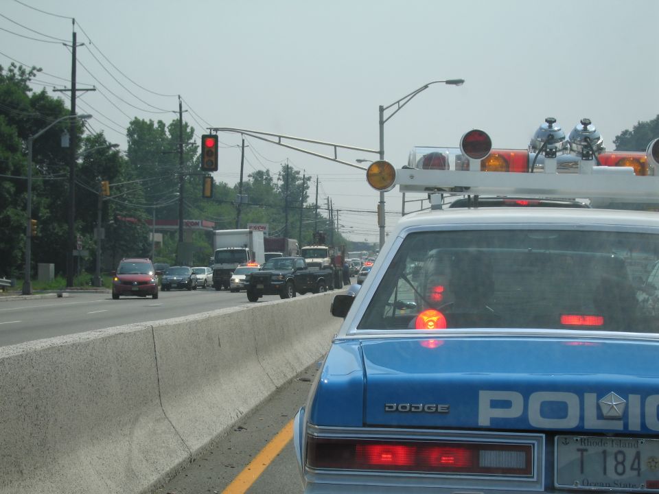 Rear of blue Dodge POLICE sedan at a red light in traffic