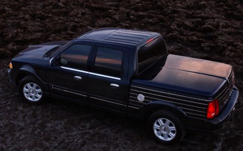1993 Ford Taurus - This dark-colored pickup truck features chrome accents along its body and a fitted tonneau cover over the bed.