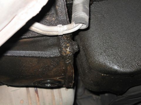 1995 Mercury Cougar - Underside view of vehicle components with visible oil leaks and grime.
