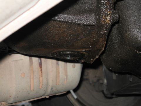 1995 Mercury Cougar - Underside view of a vehicle's transmission housing and catalytic converter, showing oil leaks.