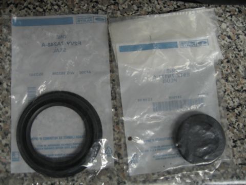 1995 Mercury Cougar - Two Ford-branded parts, a seal and a plug, are shown in their original packaging.