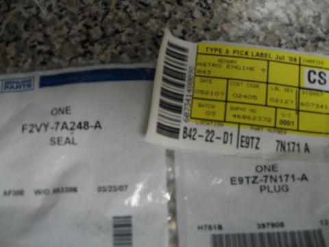 1995 Mercury Cougar - Two packages of automotive parts are shown, each with identifying labels and part numbers.