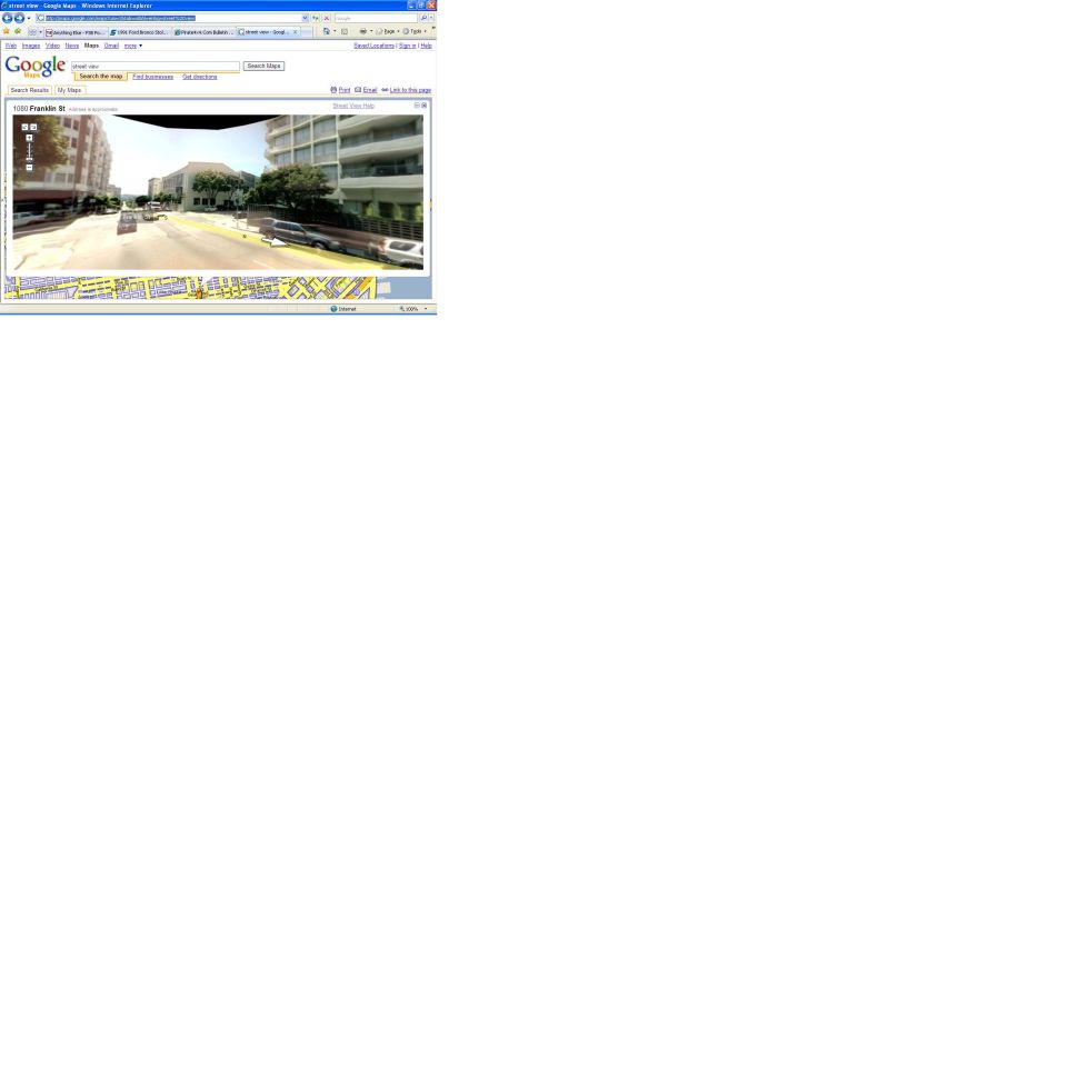 Google Street View showing a street with buildings and parked cars