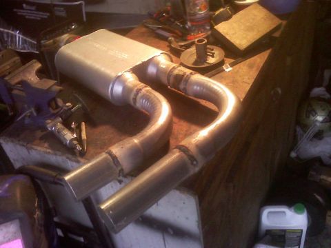 2001 Ford F-150 - A dual exhaust system, likely for a truck or SUV, is shown clamped in a vise, ready for installation or modification.