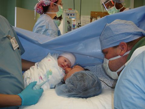 1989 Ford Bronco - A newborn baby is held by medical staff during a procedure in an operating room.