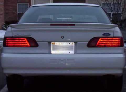 1993 Ford Taurus - Rear view of a white 1992 Ford Taurus sedan with illuminated taillights and an Indiana license plate.