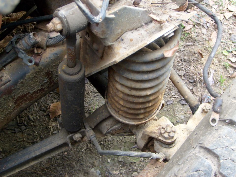 Close-up of a rusty engine swap part with a SuperMotors logo