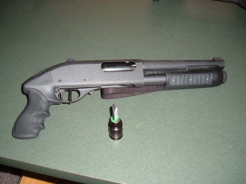 1979 Ford Bronco - A black shotgun and a cartridge are displayed on a green surface.