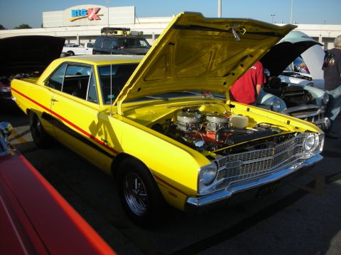 1998 Ford Crown Victoria - Yellow 1970 Dodge Dart at a car show, hood open revealing the engine bay.