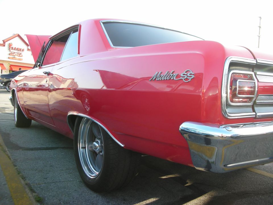Red 1960s Chevrolet Malibu SS coupe, rear quarter view