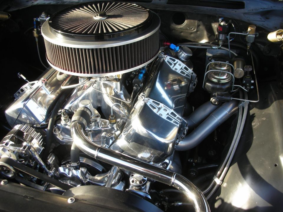 Close-up of a shiny V8 engine with a large air filter and chrome intake manifold