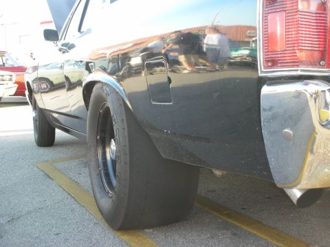 1998 Ford Crown Victoria - Close-up of a 1998 Ford Crown Victoria's rear tire and quarter panel, with another vehicle in the background.
