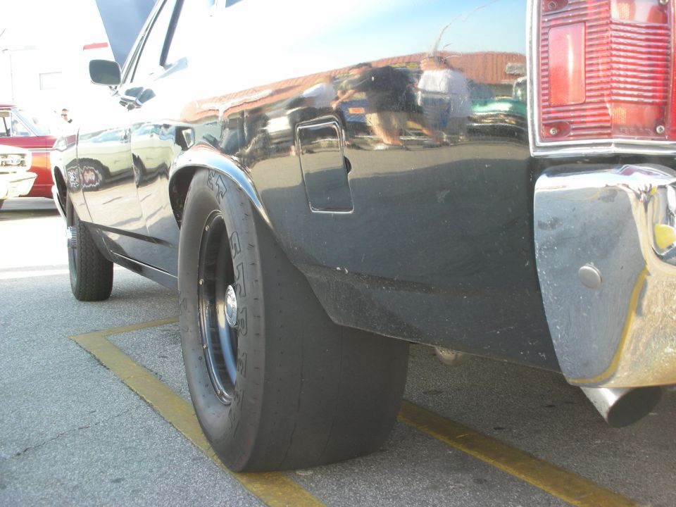 1998 Ford Crown Victoria rear quarter panel with drag radial tire. Another car is visible in the background