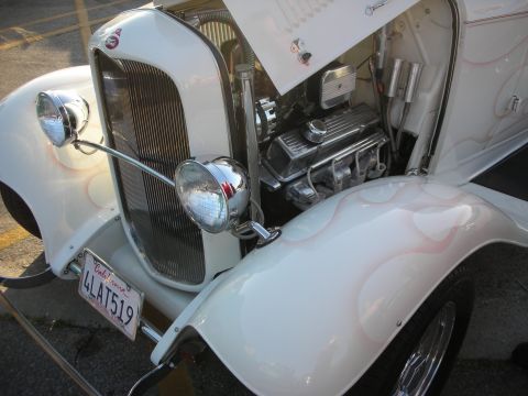 1998 Ford Crown Victoria - This custom hot rod features a white exterior with subtle flame graphics and a polished V8 engine under the hood.